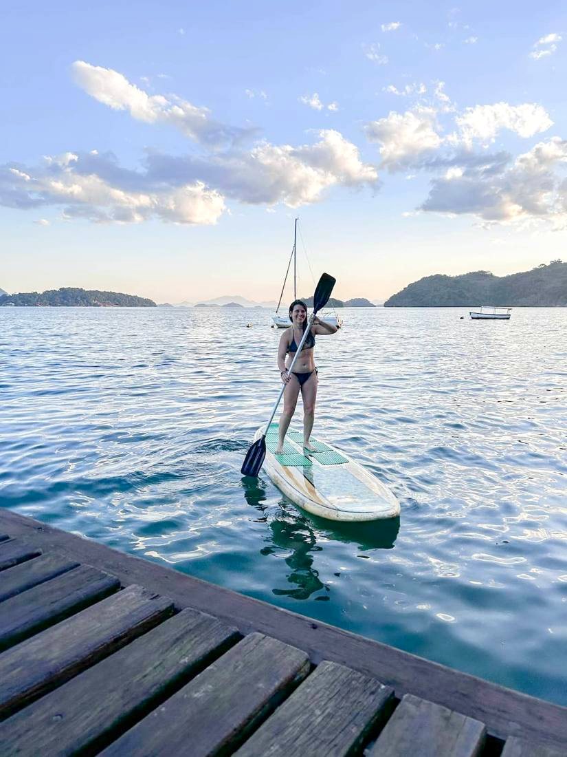 Hóspede saindo do deck da casa no stand up paddle